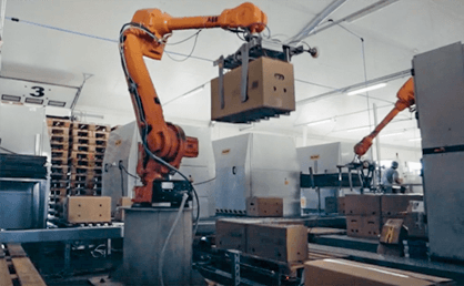 Robotizēts celtnis palīdz rūpnīcā pārvietot smagas lietas.